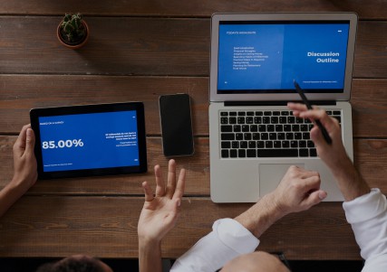 Two people analyzing information on computers